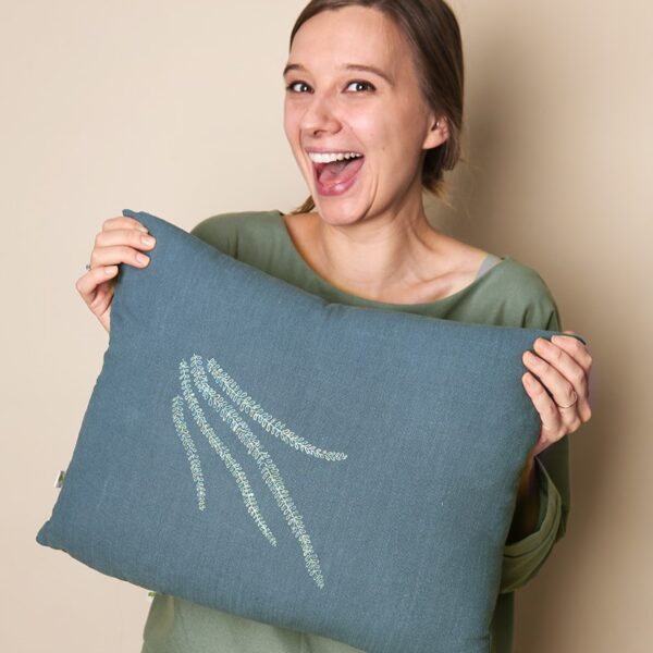 Lniana poduszka dekoracyjna z haftem autorskim przedstawiajacym gałązki z listeczkami 